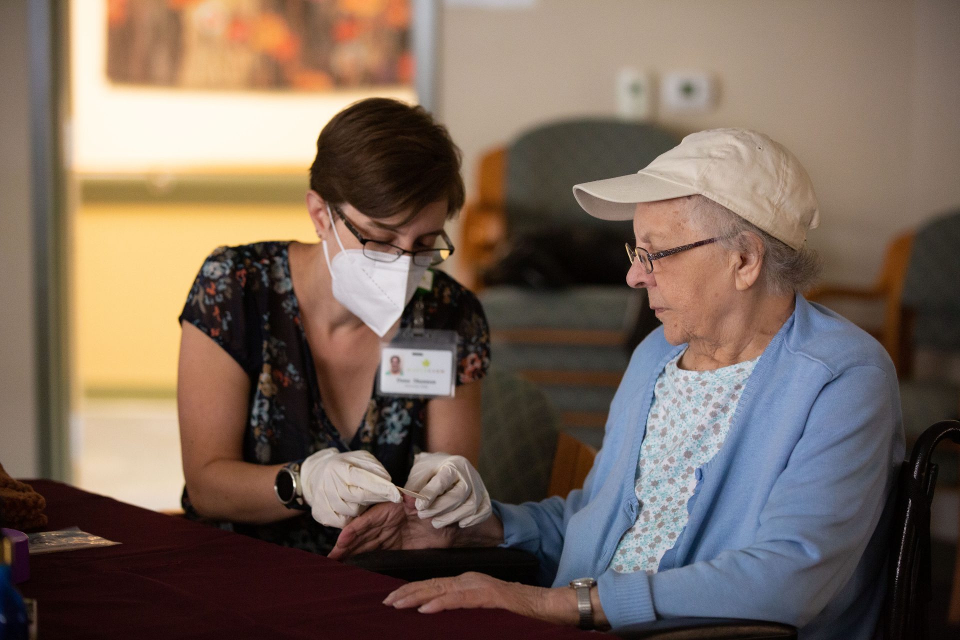 Person centered care, team member filing a residents nails.